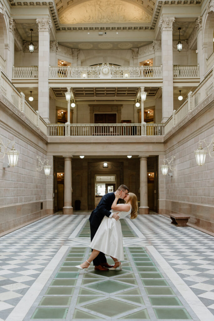 A couple doing a dip inside the atrium of Hartford City Hall for their romantic engagement session