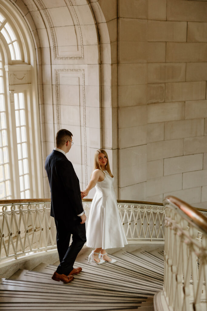 A couple walking down the steps in Hartford City Hall for their romantic engagement session