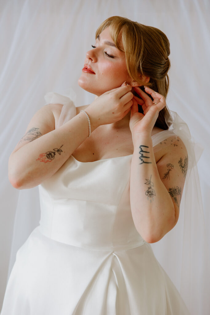 bridal portraits of bride putting in her earring