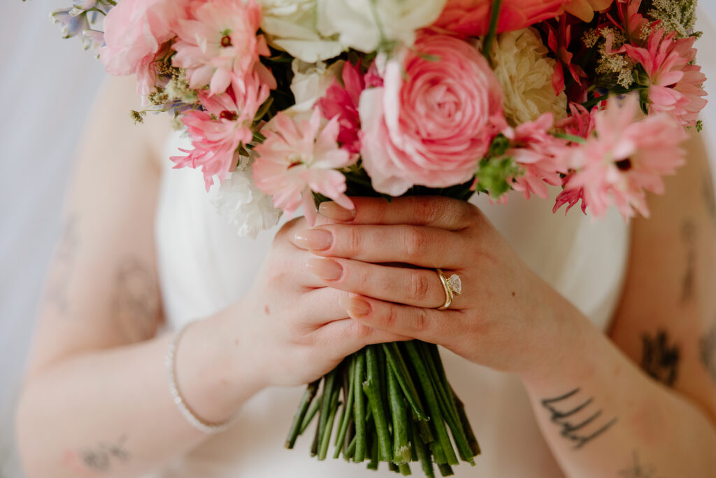close up ring shot of a bride holding her colorful bouquet