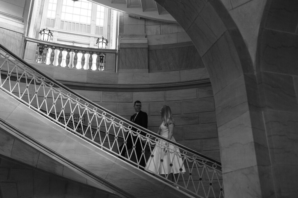 Engaged couple walking up the stairs at Hartford City Hall