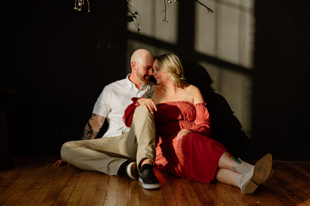 A couple sitting together for their engagement session at a studio in Hartford, Connecticut