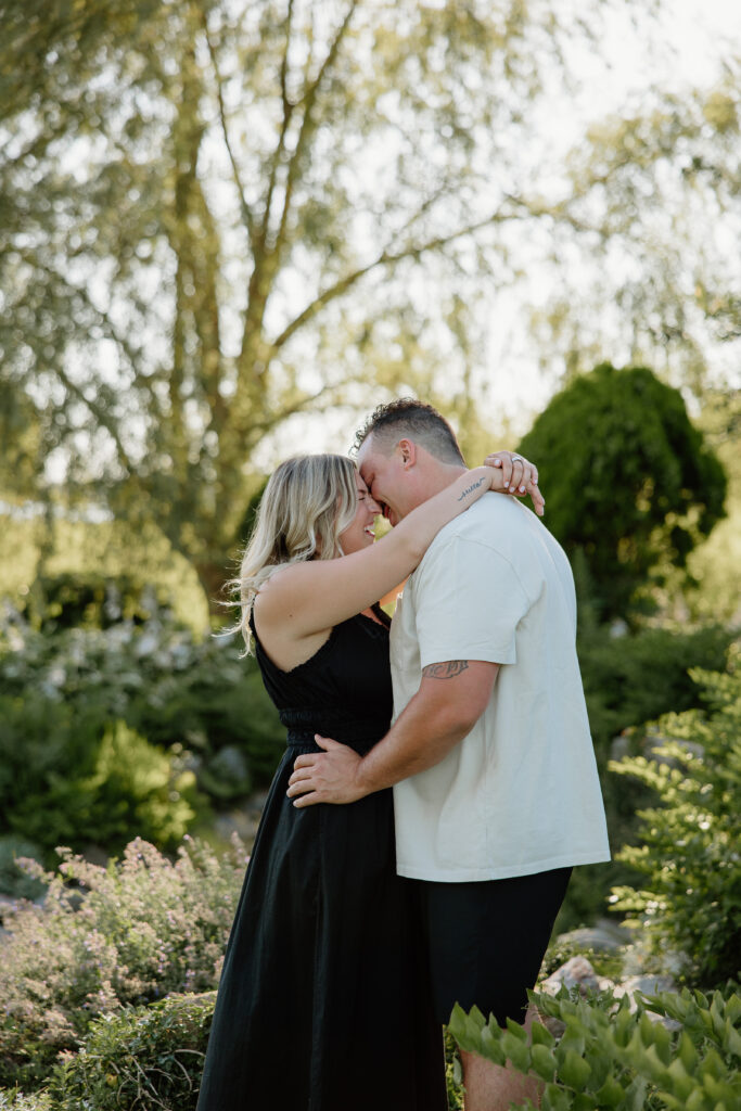 Engaged couple embracing in the gardens at Harkness Memorial State Park
