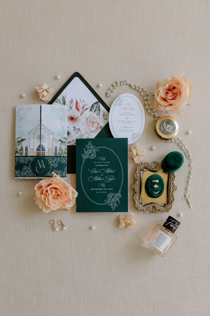 Flat lay of Clara and Matt’s wedding details including invitations, rings, florals, and personal keepsakes styled with green and peach tones.