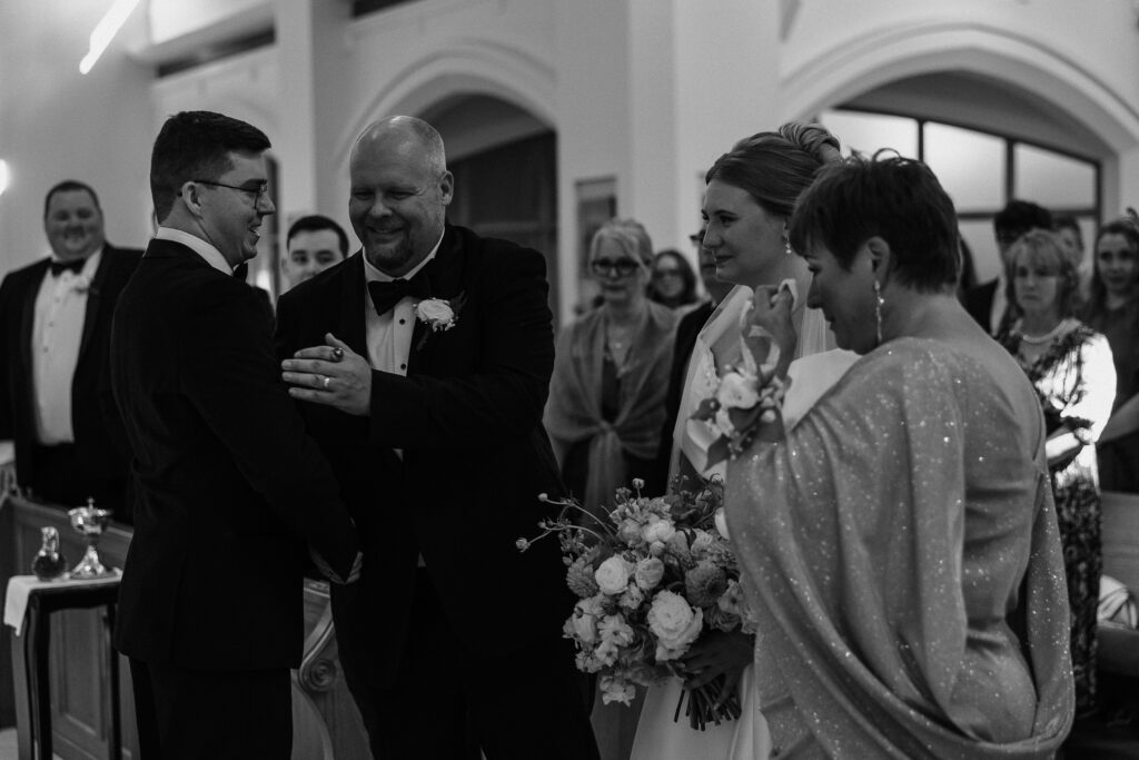 Emotional moment during the ceremony as Clara and Matt stand with their parents, sharing tears and smiles during their Curry Estate wedding.