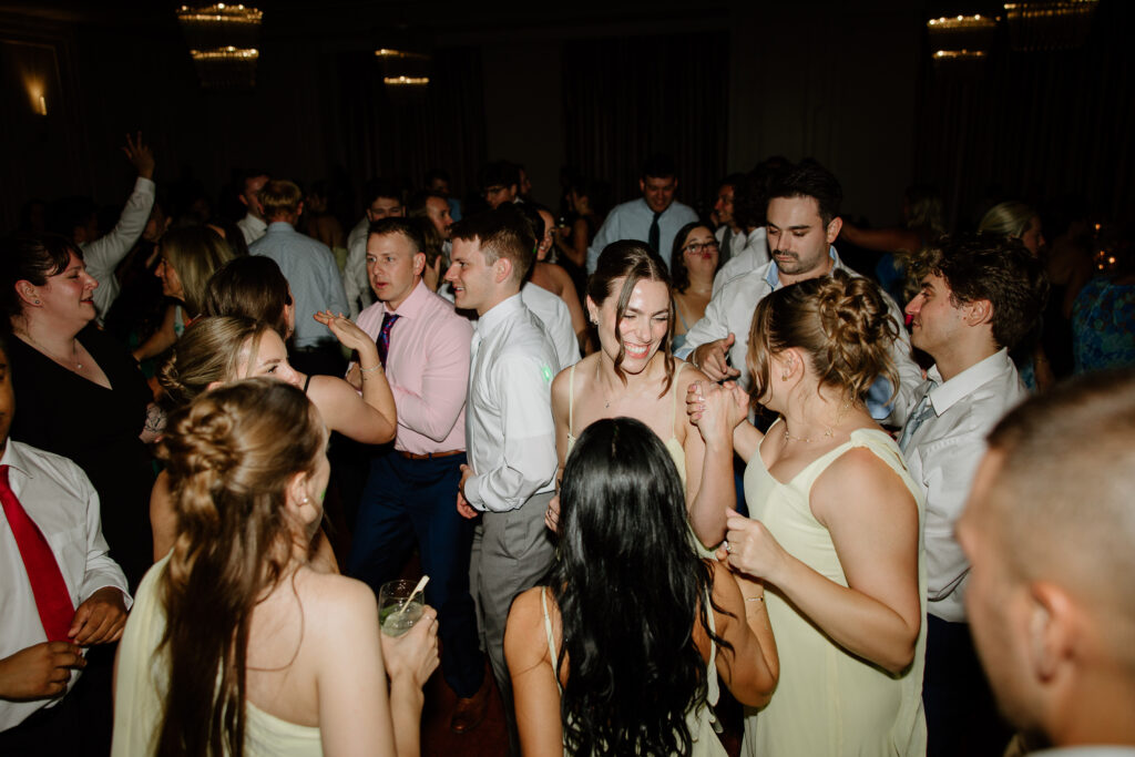 Guests and bridesmaids crowding the dance floor at a summer wedding in Connecticut