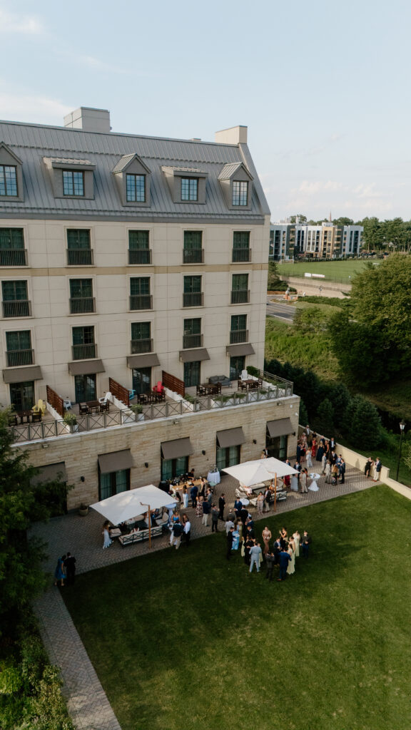 Drone view of a Delamar West Hartford wedding cocktail hour on the back lawn and terrace