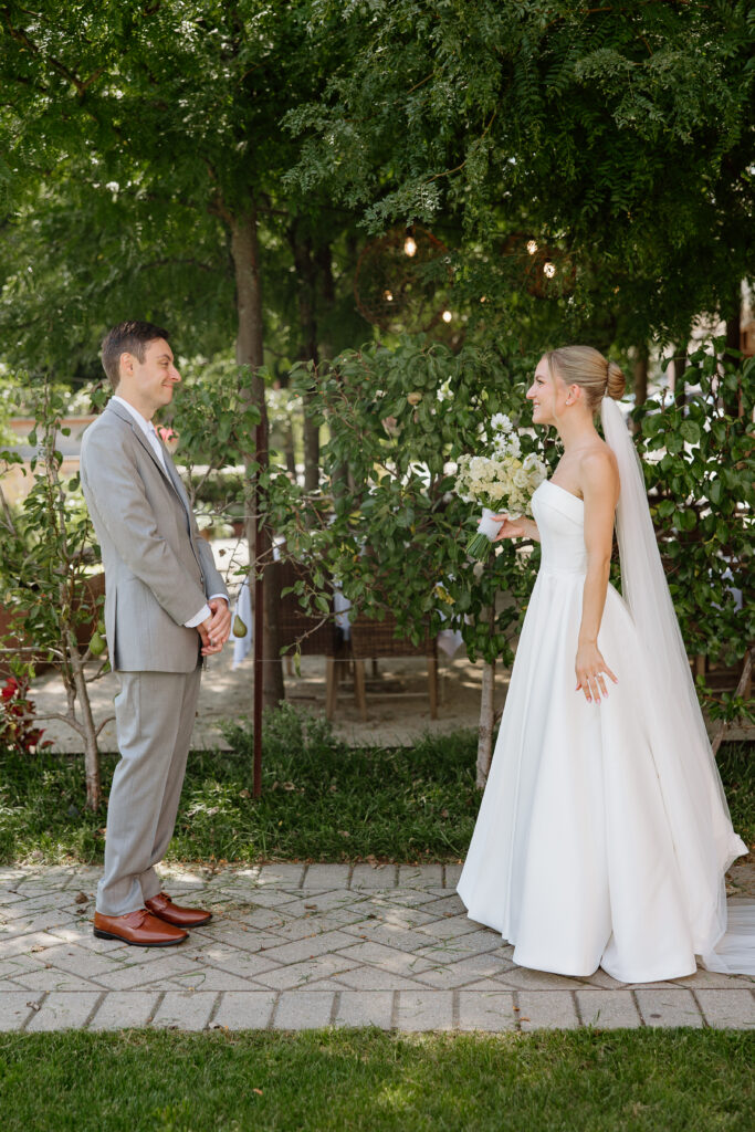 Groom turning to see his bride for the first time in the Delamar courtyard garden